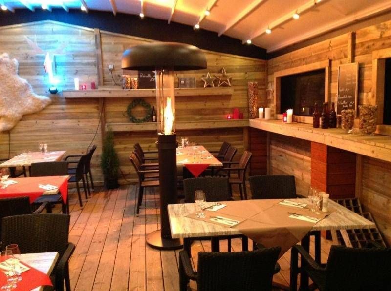 L'intérieur du Chalet 123 : murs en bois, nappes rouges et chauffage à flamme
