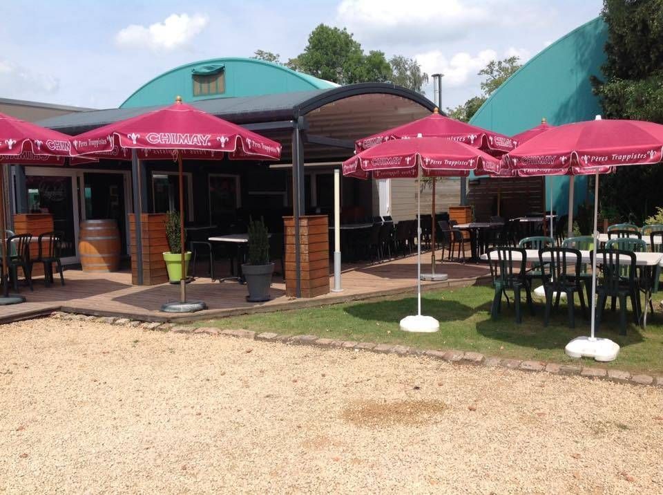 Le club-house du Longchamps et sa terrasse, parasols ouverts